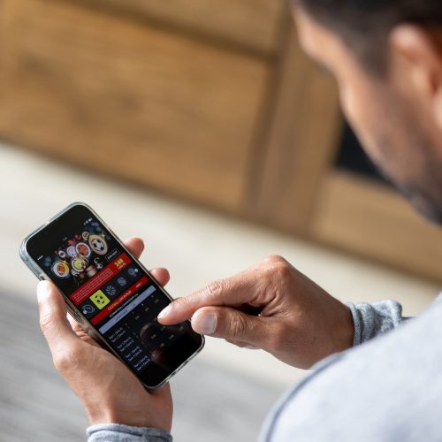 Man gambling online on a football match using his cell phone - lifestyle concepts